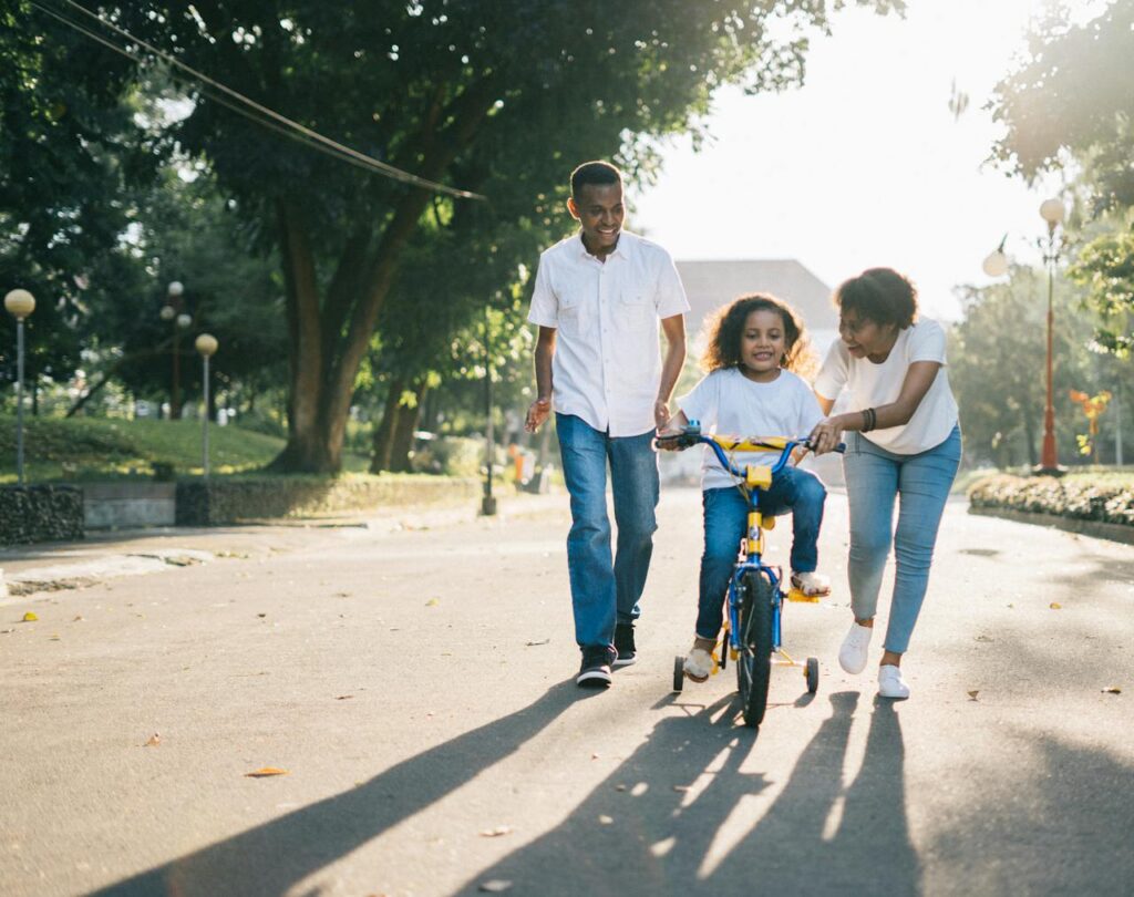 Family practicing healthy habits by riding a bike