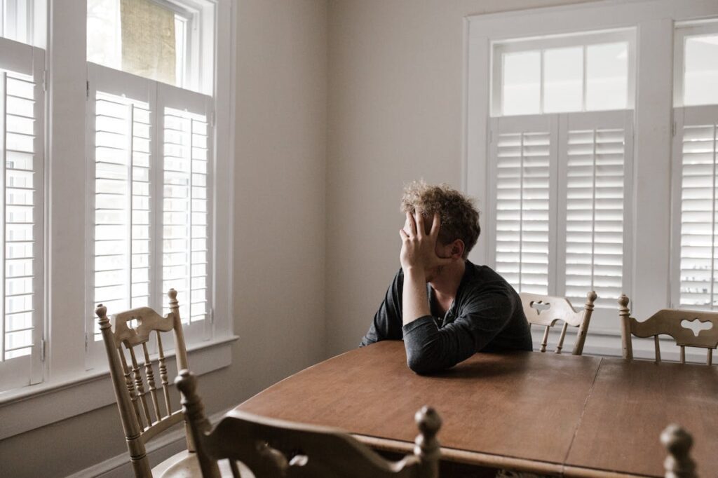 A man sitting at a table looking distressed